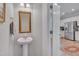 Charming powder room features a pedestal sink, ornate mirror, and is conveniently located near the kitchen at 900 Ambergate Sta, Apex, NC 27502