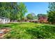 View of the sprawling backyard, trees, and the back of the house with a covered patio at 926 Allister Rd, Durham, NC 27703