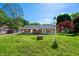 Expansive backyard featuring a well-maintained lawn, mature trees, and a cozy covered patio at 926 Allister Rd, Durham, NC 27703