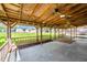 Spacious covered back patio with wooden beams and a concrete floor at 926 Allister Rd, Durham, NC 27703