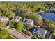 Stunning aerial view of an estate home in a wooded community near a lake at 944 Alden Bridge Dr, Cary, NC 27519