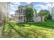 Back of the home featuring multiple screened-in porches and large, green yard at 944 Alden Bridge Dr, Cary, NC 27519