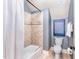 Full bathroom featuring tile shower, tub with curtain, toilet, and blue artwork above, with neutral tile flooring at 944 Alden Bridge Dr, Cary, NC 27519