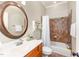 Well-lit bathroom with vanity sink, round mirror and tiled shower-tub combination at 944 Alden Bridge Dr, Cary, NC 27519