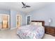 Bedroom featuring floral bedding, ceiling fan and ensuite bathroom in an open floorplan with carpet flooring at 944 Alden Bridge Dr, Cary, NC 27519