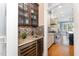 Butler's pantry with wine fridge, mosaic tile, sink, and cabinetry at 944 Alden Bridge Dr, Cary, NC 27519