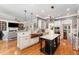 Open kitchen with island, stainless appliances, and a view to living room and breakfast nook at 944 Alden Bridge Dr, Cary, NC 27519