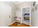 Hallway with wooden floors, a mudroom bench with hooks, and an open doorway into a bedroom with ensuite at 944 Alden Bridge Dr, Cary, NC 27519