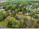 An aerial view showcasing the community with lush green trees, several rooftops, and neighborhood streets at 95 Torrington Ave, Franklinton, NC 27525
