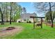 Expansive backyard featuring a fire pit, swing set, and lush green lawn at 95 Torrington Ave, Franklinton, NC 27525