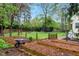 The backyard features raised garden beds, a swing, fire pit, and wooden fence for privacy at 95 Torrington Ave, Franklinton, NC 27525