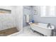 Bright bathroom showcases a clawfoot tub and a walk-in shower with unique blue patterned tile accents at 1023 Kent St, Durham, NC 27707