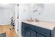 Bathroom features a sleek blue vanity, white countertop, modern fixtures, and mirror at 1023 Kent St, Durham, NC 27707