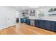 Well-lit kitchen with navy lower cabinets, stainless steel appliances, and wood floors at 1023 Kent St, Durham, NC 27707