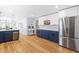 Open concept kitchen with white and navy cabinets, stainless appliances, and hardwood floors at 1023 Kent St, Durham, NC 27707