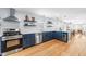 Open kitchen with a stainless steel stove, updated cabinets, and hardwood floors at 1023 Kent St, Durham, NC 27707