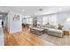 Open-concept living room with hardwood floors, a sectional sofa, and a view into the dining area, ideal for modern living at 1023 Kent St, Durham, NC 27707