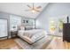 Spacious main bedroom featuring a ceiling fan, large bed, and access to a deck at 1023 Kent St, Durham, NC 27707