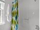 Clean bath with a white shower/tub, patterned curtain, window, and towel rack at 105 E Murray Ave, Durham, NC 27704