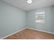 Well-lit bedroom with laminated wood flooring, a window, and neutral walls at 105 E Murray Ave, Durham, NC 27704
