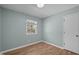 Modest bedroom features wood laminate flooring, a window, and a door to the hall at 105 E Murray Ave, Durham, NC 27704