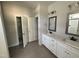 Bathroom featuring a double vanity, decorative mirrors, and a linen closet at 107 Tee Dr, Selma, NC 27576