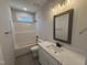Bathroom featuring a tub, decorative mirror, and white marble countertop at 107 Tee Dr, Selma, NC 27576