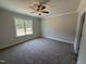 A cozy bedroom featuring neutral carpeting, large window, and clean, modern finishes at 107 Tee Dr, Selma, NC 27576