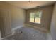 A light-filled room with a window offering views of the outdoors and unfinished flooring at 107 Tee Dr, Selma, NC 27576