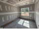 Bright bedroom with a large window, unfinished walls, and ceiling details, with customization options at 107 Tee Dr, Selma, NC 27576