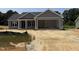 New construction home featuring a two-car garage, gray siding, and covered front porch at 107 Tee Dr, Selma, NC 27576