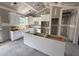 Modern kitchen features white cabinetry, a central island, abundant counter space, and is awaiting final finishes at 107 Tee Dr, Selma, NC 27576