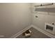 Functional laundry area with shelving, hookups, and stylish tile flooring, offering convenience and modern appeal at 107 Tee Dr, Selma, NC 27576