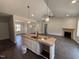 Open-concept living space with a modern kitchen island, sleek dark floors and a cozy fireplace at 107 Tee Dr, Selma, NC 27576