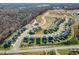 Wide aerial view of a developed community highlighting the arrangement of houses, surrounding trees, and landscape at 1075 Fairhaven Dr # 51, Mebane, NC 27302