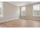 Bright bedroom featuring three large windows and light-colored hardwood flooring at 1075 Fairhaven Dr # 51, Mebane, NC 27302