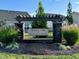 Stone and wood sign for Courtyards at Magnolia Glen community with landscaping and clear blue sky at 1075 Fairhaven Dr # 51, Mebane, NC 27302