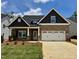 Charming brick home with a two-car garage, covered porch, and beautifully landscaped front yard under a blue sky at 1075 Fairhaven Dr # 51, Mebane, NC 27302