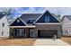 Charming single-Gathering home with brick and blue siding, two-car garage, and inviting front porch at 1075 Fairhaven Dr # 51, Mebane, NC 27302