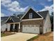 Attractive brick and siding home featuring a two-car garage, covered porch, and well-manicured landscaping at 1075 Fairhaven Dr # 51, Mebane, NC 27302