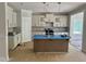 Modern kitchen featuring white cabinets, a center island, pendant lighting, and tiled backsplash at 1075 Fairhaven Dr # 51, Mebane, NC 27302