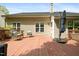 View of the back deck furnished with chairs, a small table and a large umbrella at 108 Braxberry Way, Holly Springs, NC 27540