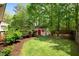 Landscaped backyard featuring a shed and lush greenery at 108 Braxberry Way, Holly Springs, NC 27540