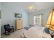 Inviting bedroom featuring soft blue walls, plush carpeting, and a bright window with natural light at 108 Braxberry Way, Holly Springs, NC 27540