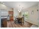 Bright eat-in kitchen area with wooden floors, decorative lighting, and a kitchen sign on the wall at 108 Braxberry Way, Holly Springs, NC 27540