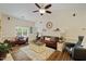 Bright living room with a ceiling fan, large windows and comfortable seating on hardwood floor at 108 Braxberry Way, Holly Springs, NC 27540