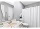 Bright bathroom featuring a shower with white curtain, updated sink, and white walls at 12 Poppy Trl, Durham, NC 27713
