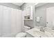 Bathroom featuring a shower with white curtain, white cabinets, and updated sink at 12 Poppy Trl, Durham, NC 27713