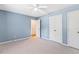 Light blue bedroom featuring neutral carpet, a ceiling fan, and white closet doors at 12 Poppy Trl, Durham, NC 27713