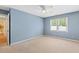 This vacant bedroom features blue walls, a window, and light-colored carpet at 12 Poppy Trl, Durham, NC 27713